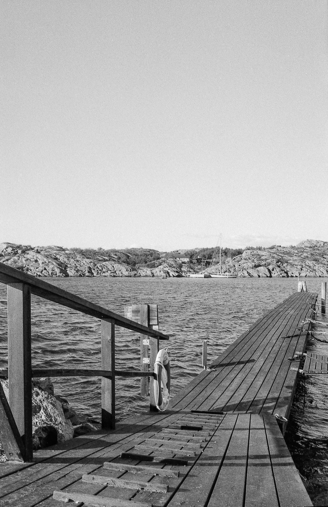 Documentary photo of an elderly Danish fisherman mending nets on a wooden pier